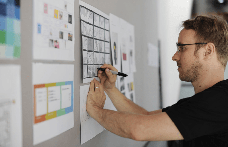 A man checking storyboard on the wall